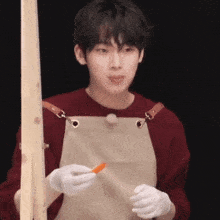 a man wearing an apron and white gloves is holding a carrot