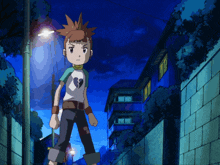 a boy with a broken heart on his shirt walks down a street at night