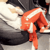 a man is sitting on a bean bag chair with his legs crossed and his pants saying p2 on them
