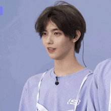 a young man wearing a purple shirt with a skechers logo on it