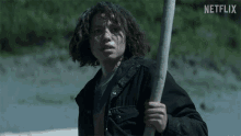 a man holding a stick with the word netflix on the bottom