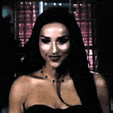 a woman with long black hair is wearing a black top