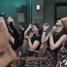 a group of young women are standing next to each other laughing and dancing .