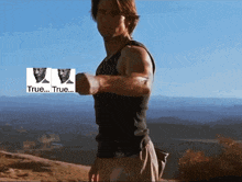 a man in a black tank top holds a dumbbell in front of a mountain with the words " true " on the bottom right