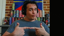 a man wearing headphones points at a can of monster