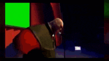 a man stands in front of a green screen and a microphone