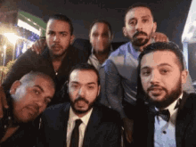 a group of men posing for a picture including one wearing a tuxedo
