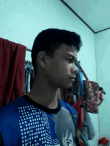 a man in a blue shirt is standing in front of a mirror
