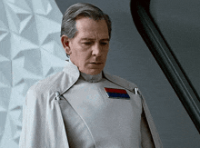 a man in a white uniform with a red and blue badge