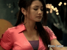 a woman in a pink shirt with the word pisau written on the bottom right
