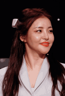 a close up of a woman 's face with a white bow in her hair