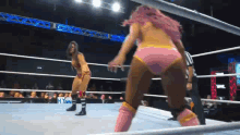 two women are wrestling in a ring with a sign that says hyunda in the background