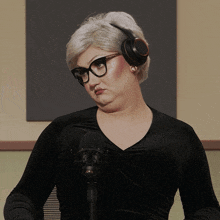 a woman wearing glasses and headphones looks at the camera