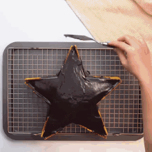 a person is decorating a star shaped cake with a spatula