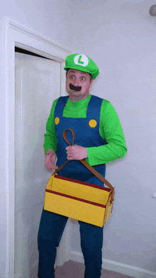 a man dressed in a luigi costume is holding a toolbox