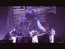 a group of people are playing instruments on a stage in front of a projection of a man in a blue hat .