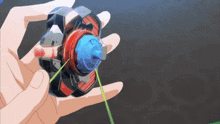 a person is holding a toy in their hand with a green string coming out of it