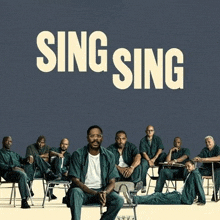 a group of men are sitting in chairs in front of a blue background with the words sing sing on it .