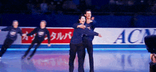 a group of ice skaters are hugging each other in front of a banner that says acn