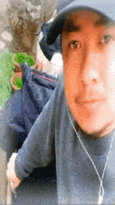 a man wearing a hat and ear buds takes a selfie