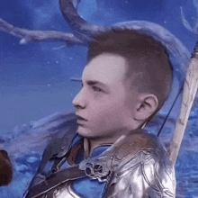 a young man in a knight 's armor is holding a sword .