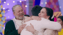 a woman is hugging a man in a white shirt