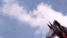 a dragon is flying through a blue sky with clouds .