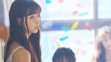 a girl with long hair is looking at the camera and making a face