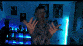 a man is standing in a room with a blue light behind him and a poster on the wall that says that