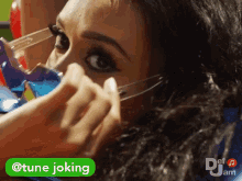 a woman is getting her makeup done with a sticker that reads tune joking