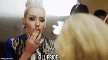 a woman is smoking a cigarette in front of a mirror and saying i kill pride .