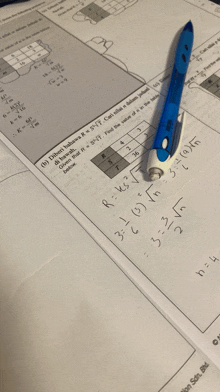 a blue pen sits on top of a piece of paper with math equations on it