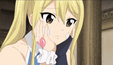 a girl with blonde hair has a tattoo on her wrist that says fairy tail