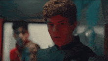 a man with curly hair is looking at the camera