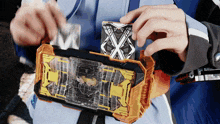 a person in a blue jacket is holding a device that has a x on it