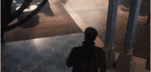 a man is standing in a dark room with columns