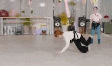a person is doing a trick on a rope in a room while a woman watches .