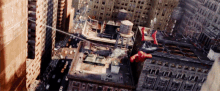 an aerial view of a city with a water tower and a spider-man flying through the air