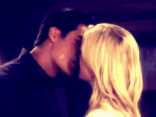 a man and a woman are kissing in front of a mirror .