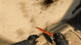 a person is holding a red knife in their hands while wearing black gloves