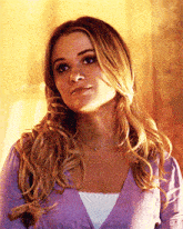 a woman is wearing a purple sweater and a white shirt