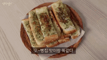 a wicker basket filled with slices of garlic bread with a caption in korean