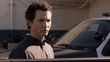 a man stands in front of a police car