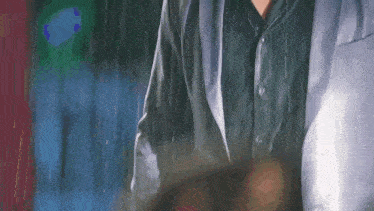 a man in a suit is standing in the rain holding a umbrella .