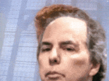 a close up of a man 's face in front of a window