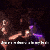 a blurred image of a crowd with the words " there are demons in my brain " at the bottom