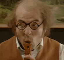 a man wearing glasses and a brown vest is playing a recorder