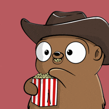 a cartoon bear wearing a cowboy hat is holding a striped popcorn box