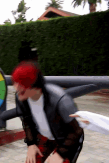 a man with red hair is standing in front of a colorful spinner