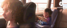 a cartoon girl is sitting in a car seat while a woman looks out the window .